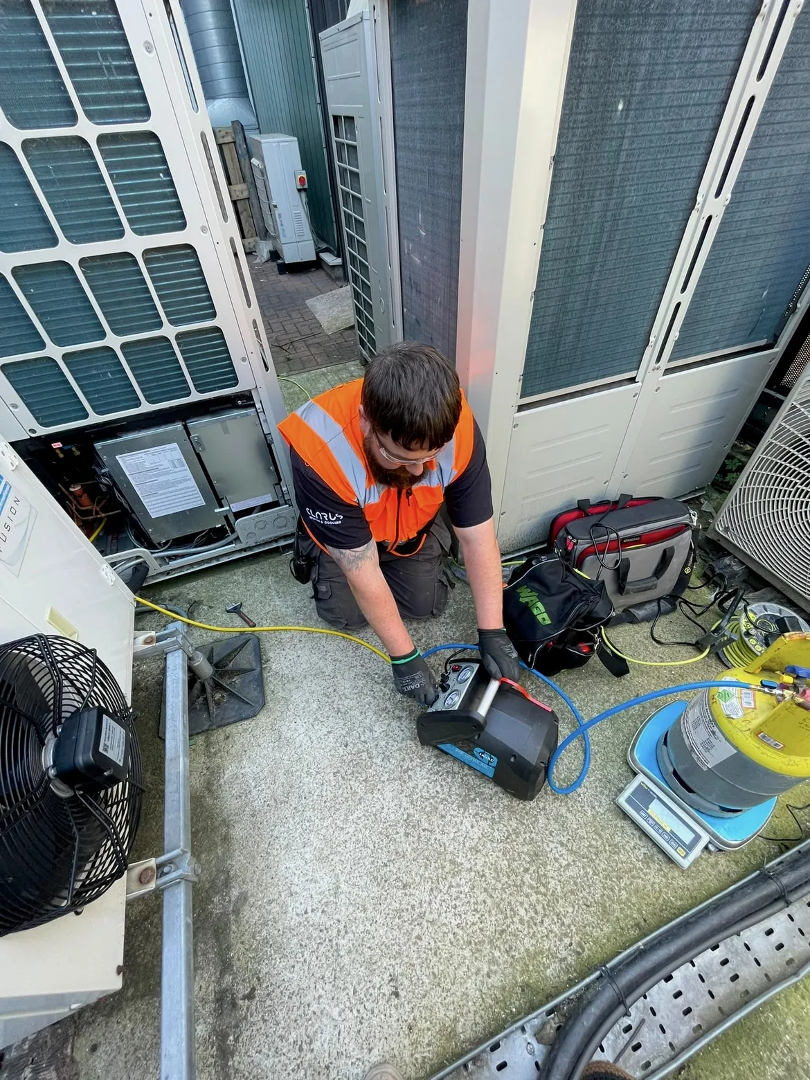 A Clarus engineer servicing commercial air-conditioning plant with refrigerant recovery equipment